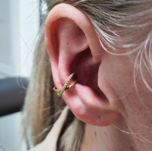 Conch piercing v zlati barvi s kristalčki, vstavljen po zaključenem celjenju v Puer Aeternus studiu v Sežani