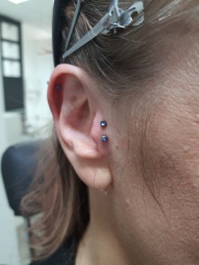 Dvojni Tragus piercing s črno ploščico vstavljen v Puer Aeternus studiu v Sežani